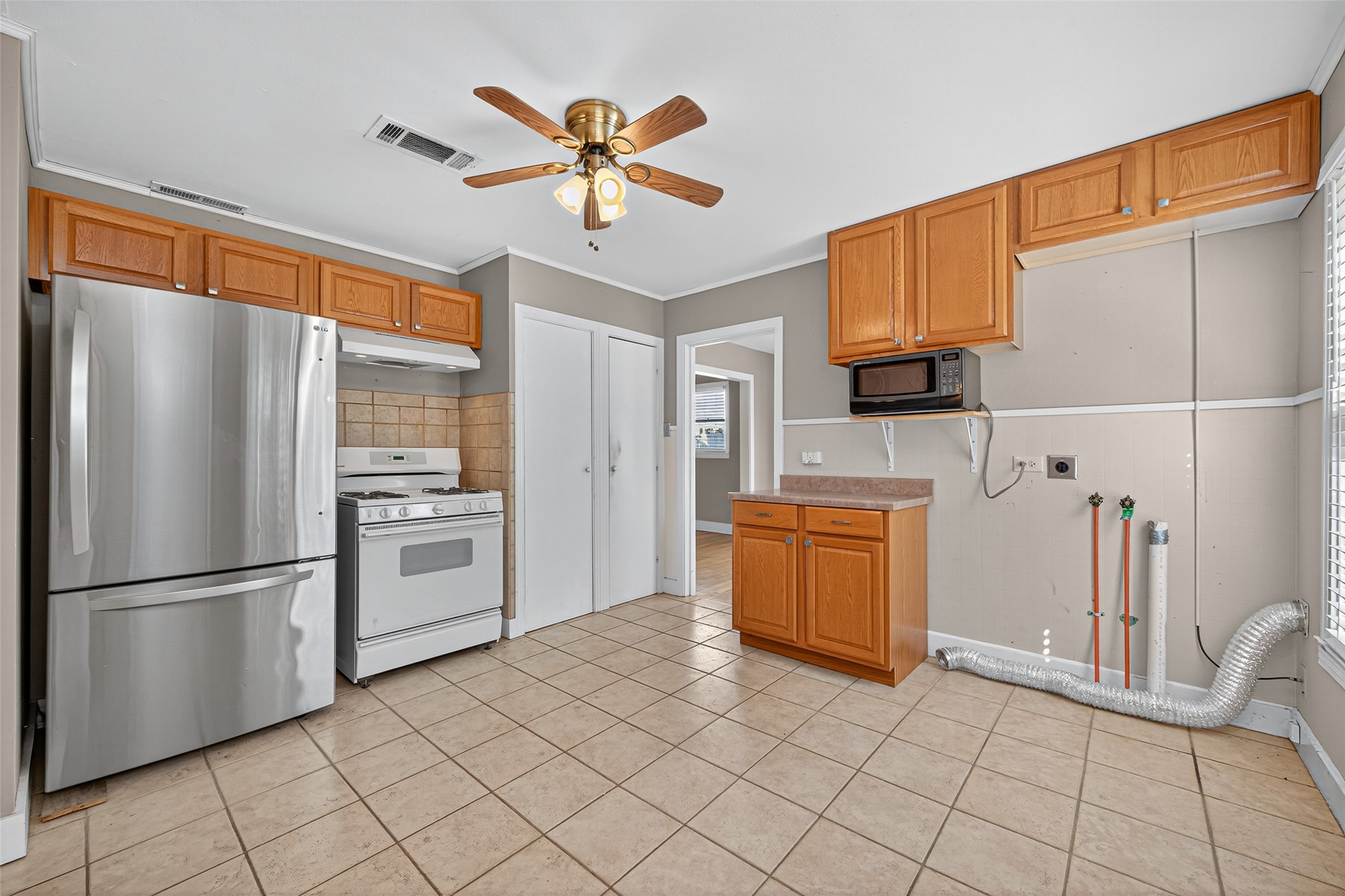 1020 Houston Street Conroe, TX 77301 - Photo 23 of 43 a kitchen with a refrigerator a stove top oven and a sink