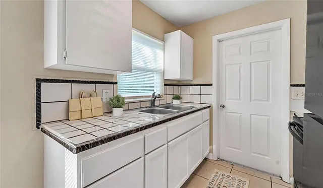 a kitchen with granite countertop a sink stove and cabinets