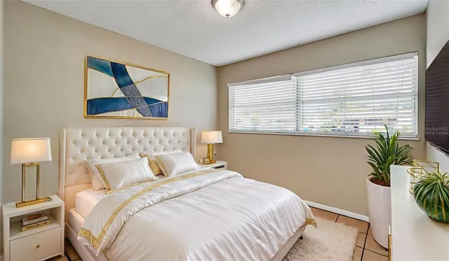 a bedroom with a bed and a potted plant