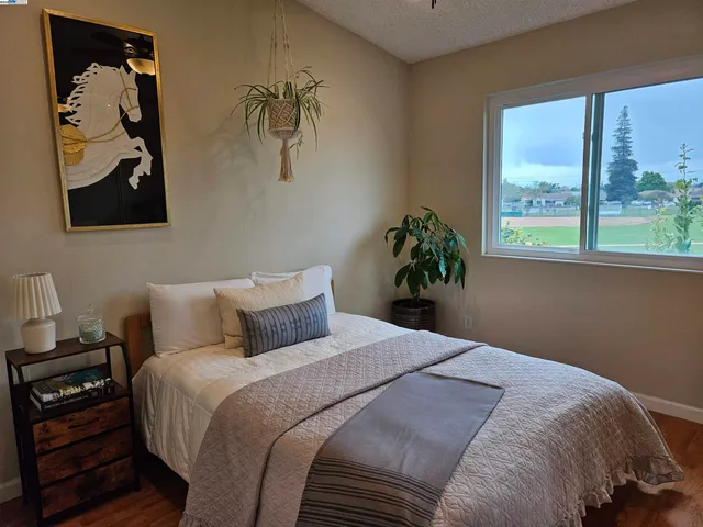 a bedroom with a bed and a painting on the wall