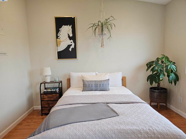 a bedroom with a large bed and a potted plant