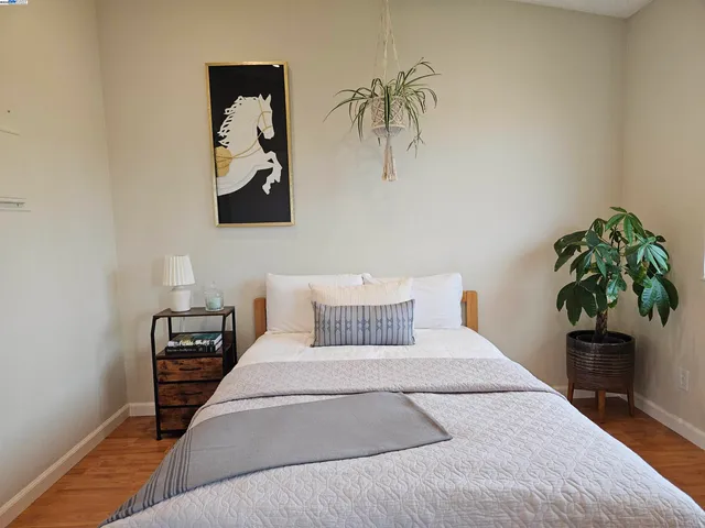 a bedroom with a large bed and a potted plant
