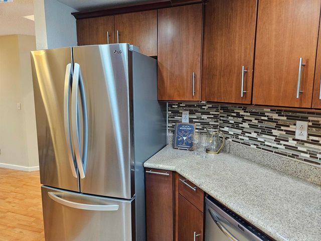 a metallic refrigerator freezer sitting in a kitchen