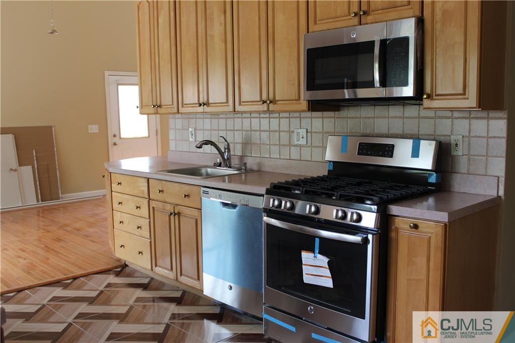 14 Kenmore Road Edison, NJ 08817 - Photo 2 of 21 a kitchen with stainless steel appliances a stove a microwave a sink and cabinets
