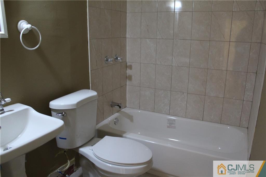 14 Kenmore Road Edison, NJ 08817 - Photo 11 of 21 a white toilet sitting next to a bath tub