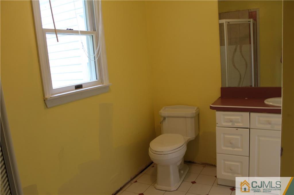 14 Kenmore Road Edison, NJ 08817 - Photo 14 of 21 a bathroom with a toilet sink and mirror