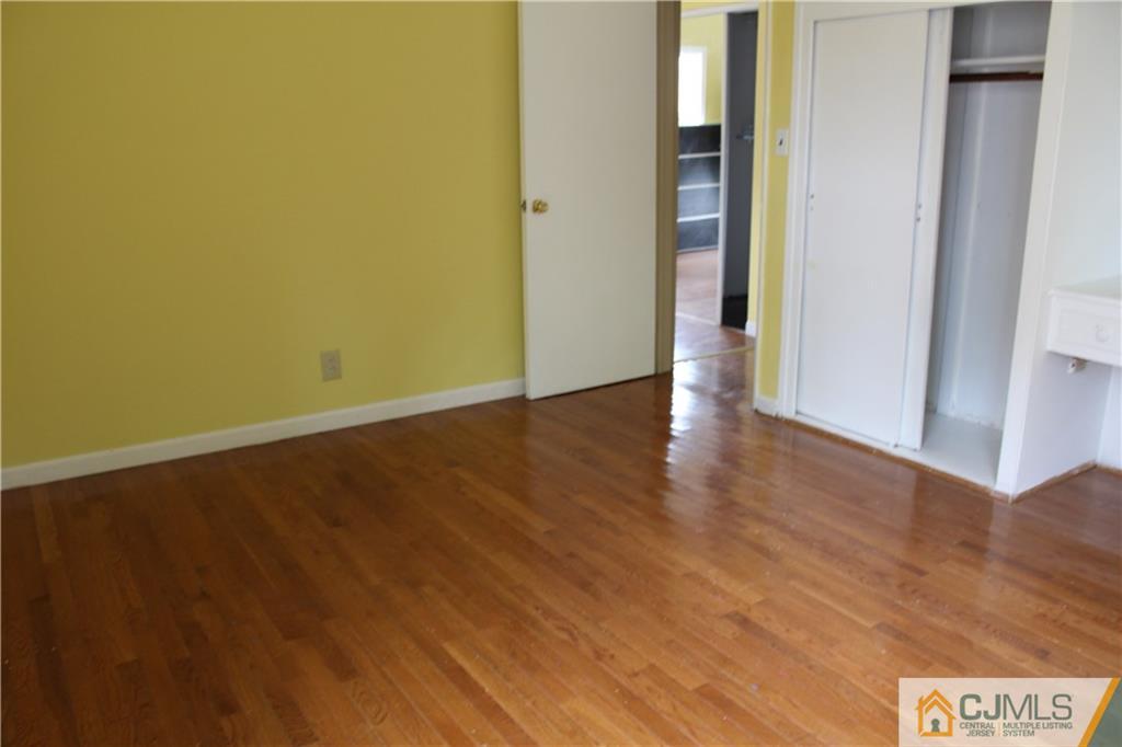 14 Kenmore Road Edison, NJ 08817 - Photo 16 of 21 a view of an empty room with wooden floor and closet