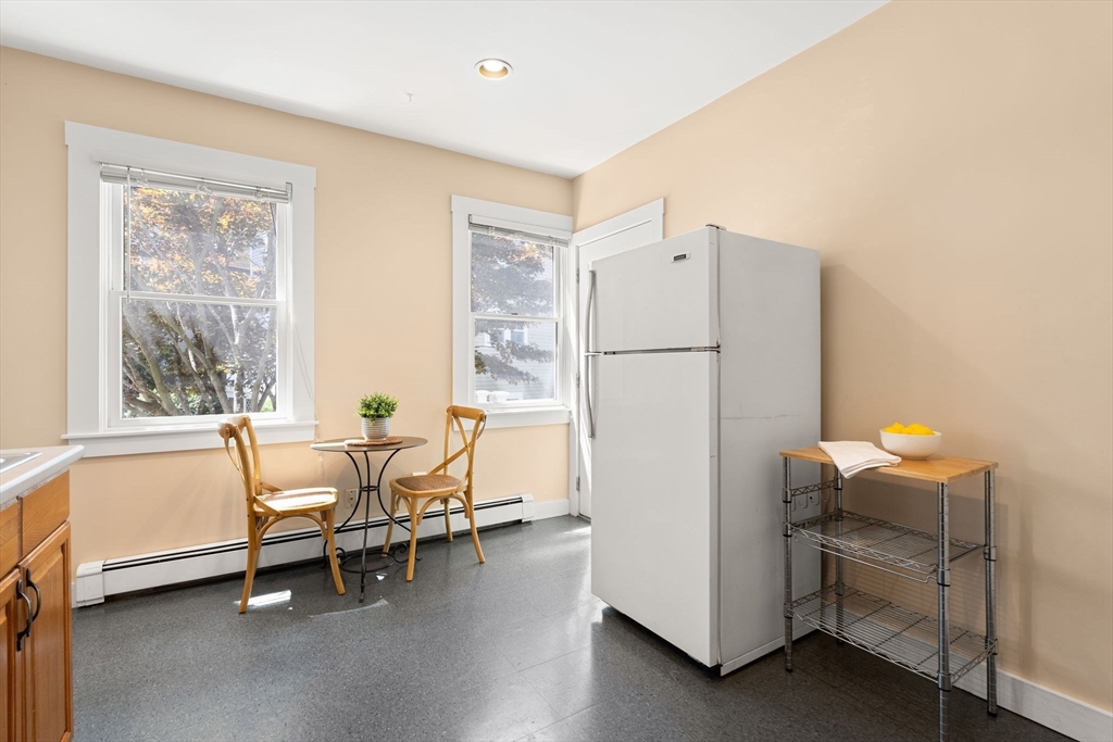 52 Lewis Avenue Arlington, MA 02474 - Photo 25 of 40 a white kitchen with a refrigerator a table and chairs