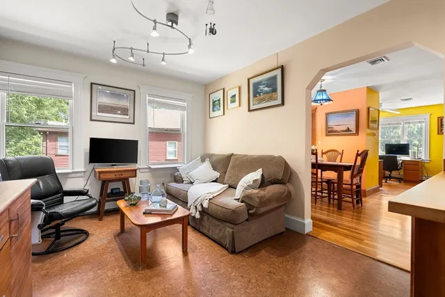 a living room with furniture kitchen view and a large window