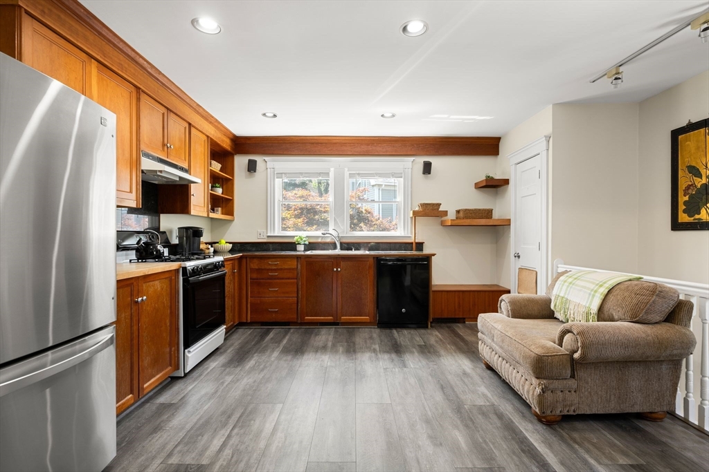 52 Lewis Avenue Arlington, MA 02474 - Photo 7 of 40 a kitchen with stainless steel appliances granite countertop a stove a sink dishwasher a refrigerator and a dining table with wooden floor
