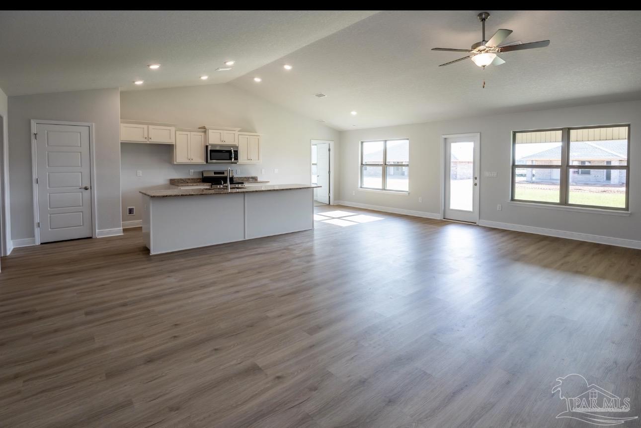 7645 Small Pnes Street Milton, FL 32583 - Photo 2 of 5 a large kitchen with stainless steel appliances granite countertop a large counter top a sink and a refrigerator