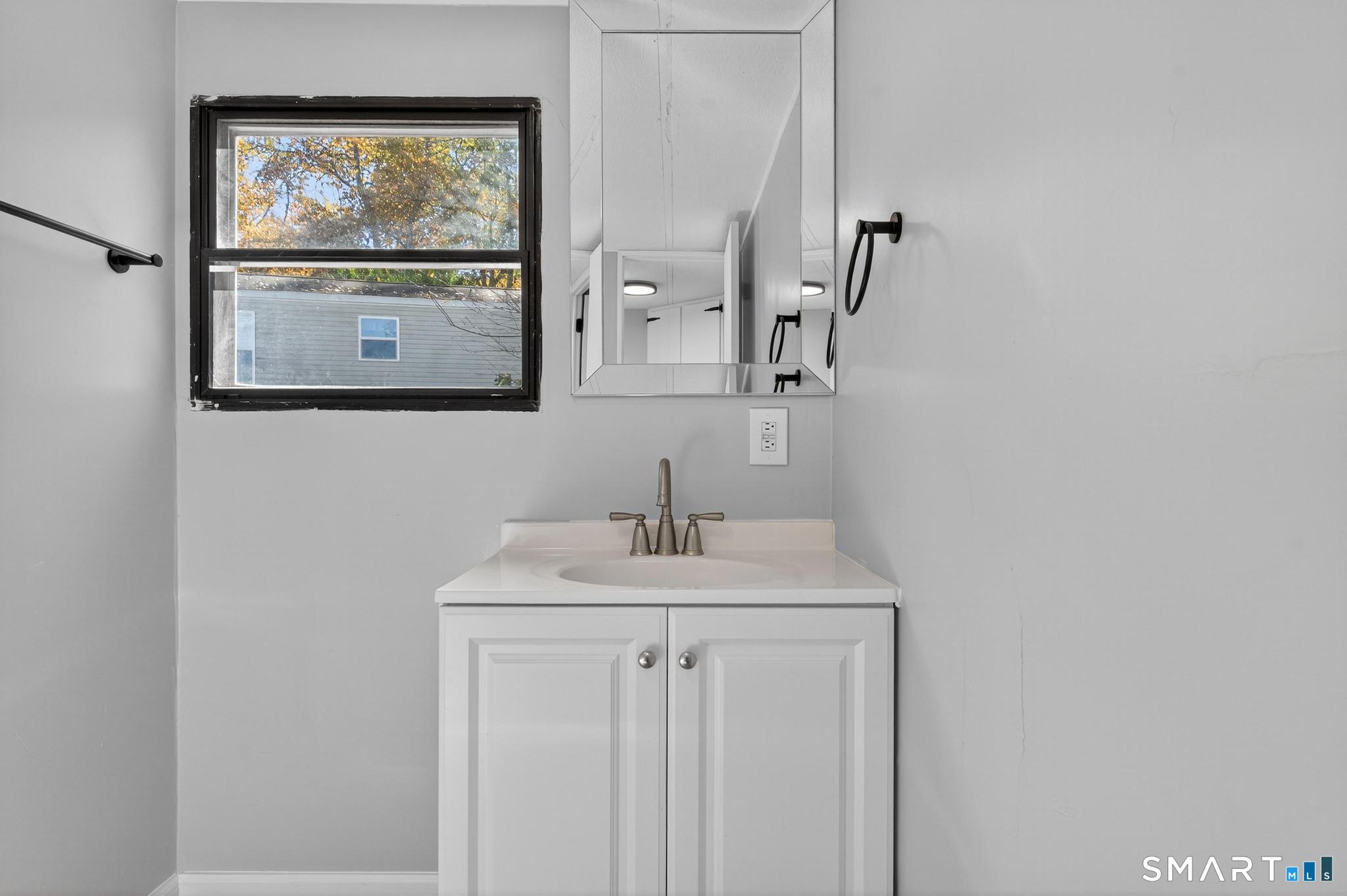 32 Nashua Street Norwich, CT 06360 - Photo 17 of 19 a bathroom with a sink a mirror and a window
