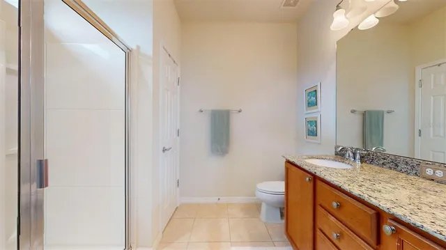 a bathroom with a granite countertop sink toilet and shower