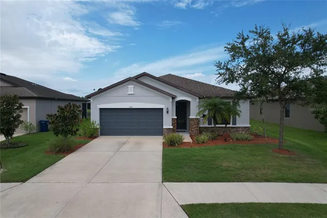 a front view of house with garden and trees