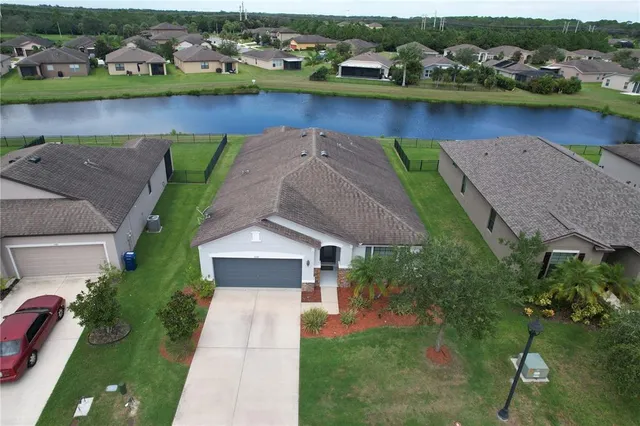 an aerial view of a house with a garden and lake view