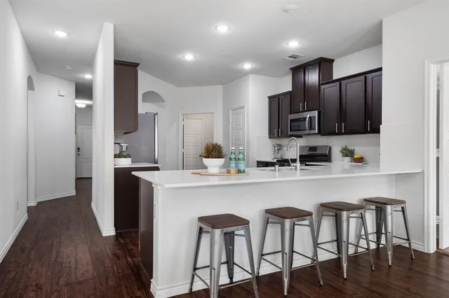 a kitchen with kitchen island granite countertop a sink and refrigerator