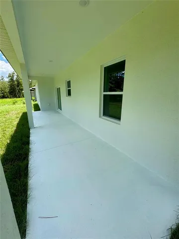 a view of empty room with wooden floor and furniture