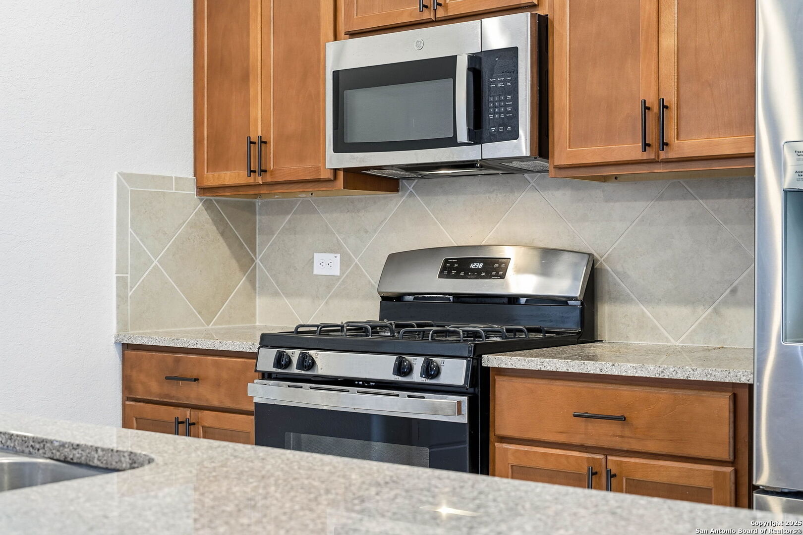 9102 Devils River Converse, TX 78109 - Photo 8 of 34 a kitchen with stainless steel appliances granite countertop a stove and a microwave