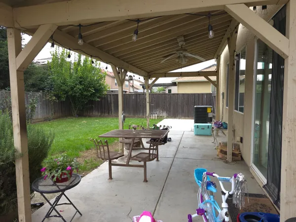 a view of a patio with a table chairs and a backyard