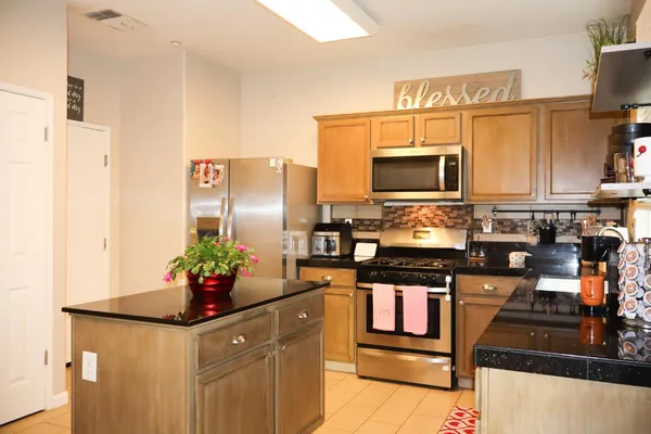 a kitchen with stainless steel appliances granite countertop a stove refrigerator and microwave