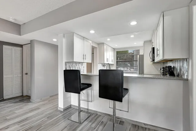 a kitchen with stainless steel appliances granite countertop a refrigerator and a stove top oven