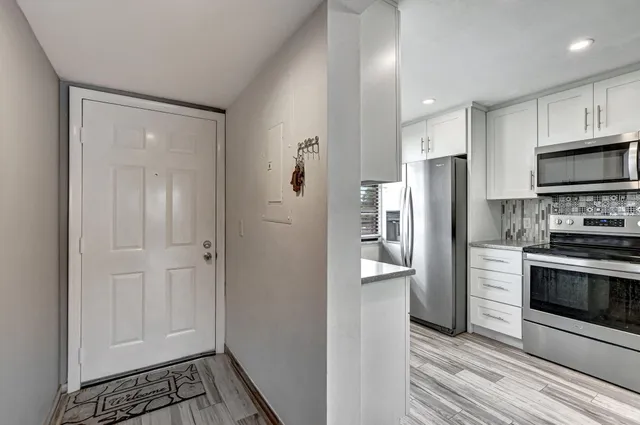 a kitchen with stainless steel appliances granite countertop a refrigerator and a stove top oven