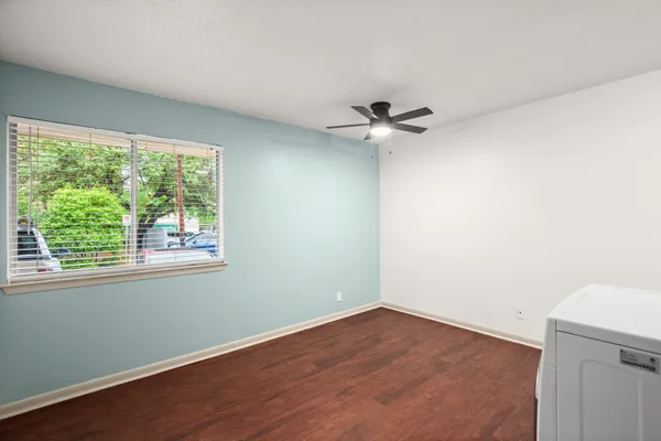 an empty room with a window and a ceiling fan