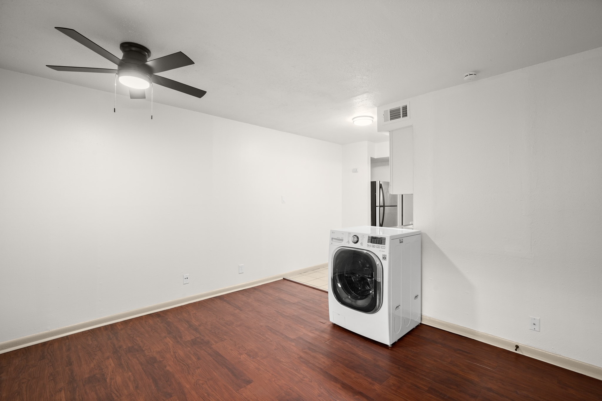 1010 West 23rd Street, Unit 3 Austin, TX 78705 - Photo 7 of 15 a view of a livingroom with wooden floor a ceiling fan and staircase