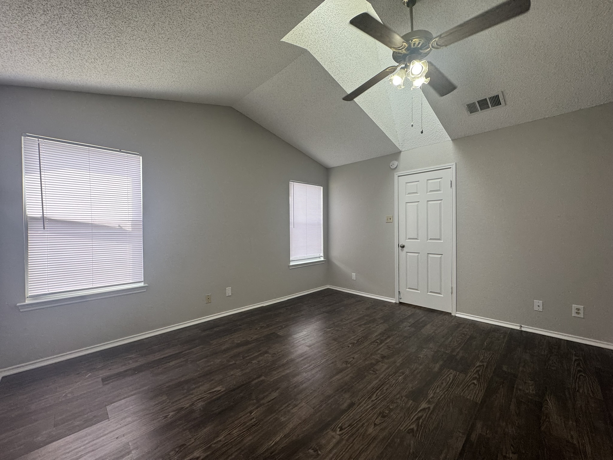 522 Cutty Trail, Unit B Lakeway, TX 78734 - Photo 13 of 20 Varying ceiling heights define this bedroom, complete with rich dark wood flooring.