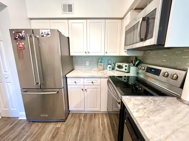 a kitchen with a refrigerator a stove a microwave and cabinets