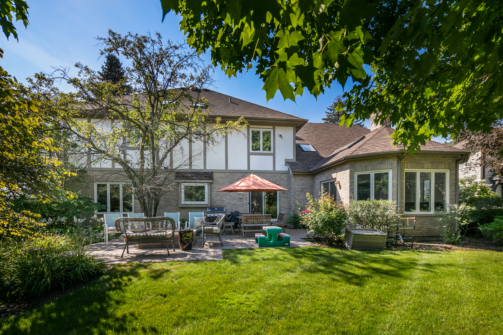 23W250 Hampton Circle Naperville, IL 60540 - Photo 5 of 42 a backyard of a house with table and chairs under an umbrella
