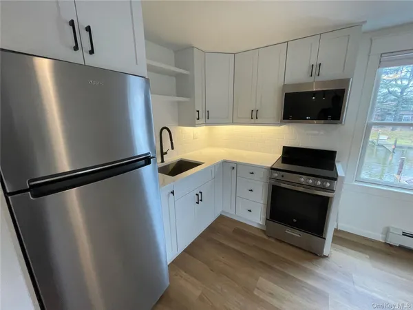 a kitchen with stainless steel appliances a refrigerator a stove a microwave and cabinets