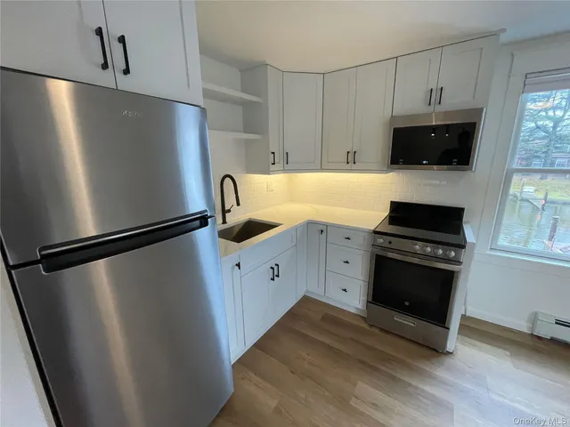 a kitchen with stainless steel appliances a refrigerator a stove a microwave and cabinets