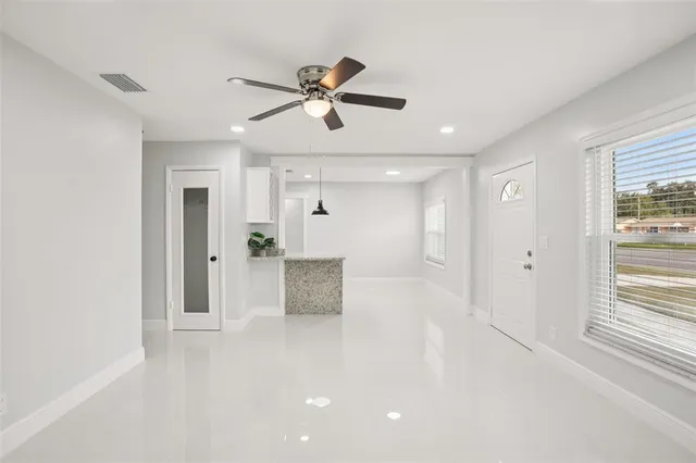 a kitchen with stainless steel appliances granite countertop a refrigerator a sink dishwasher a stove and white cabinets with wooden floor