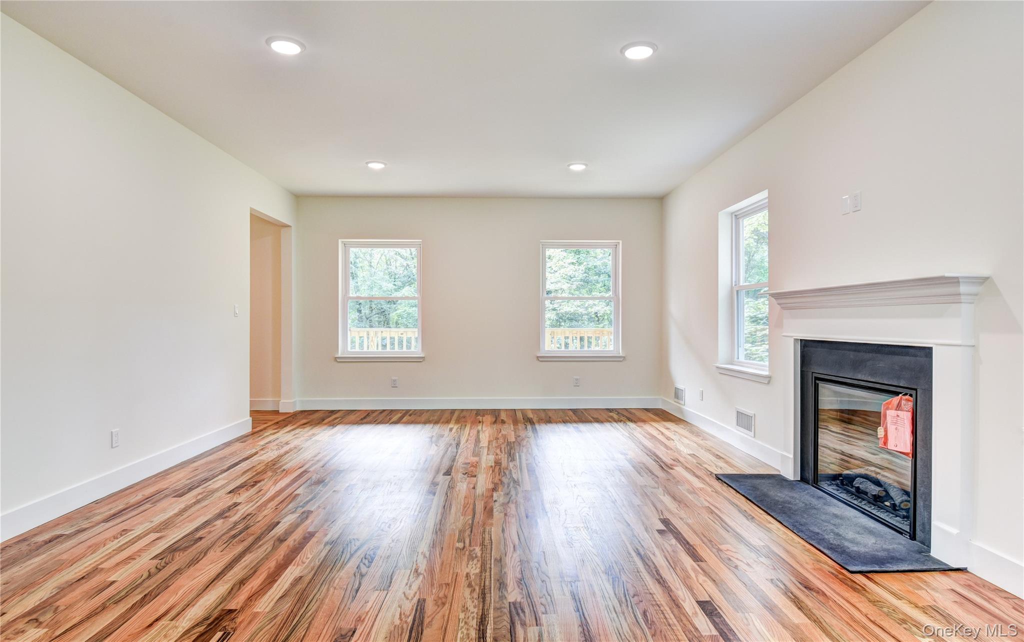 20 Wells Road Newburgh, NY 12550 - Photo 14 of 47 an empty room with wooden floor fireplace and windows