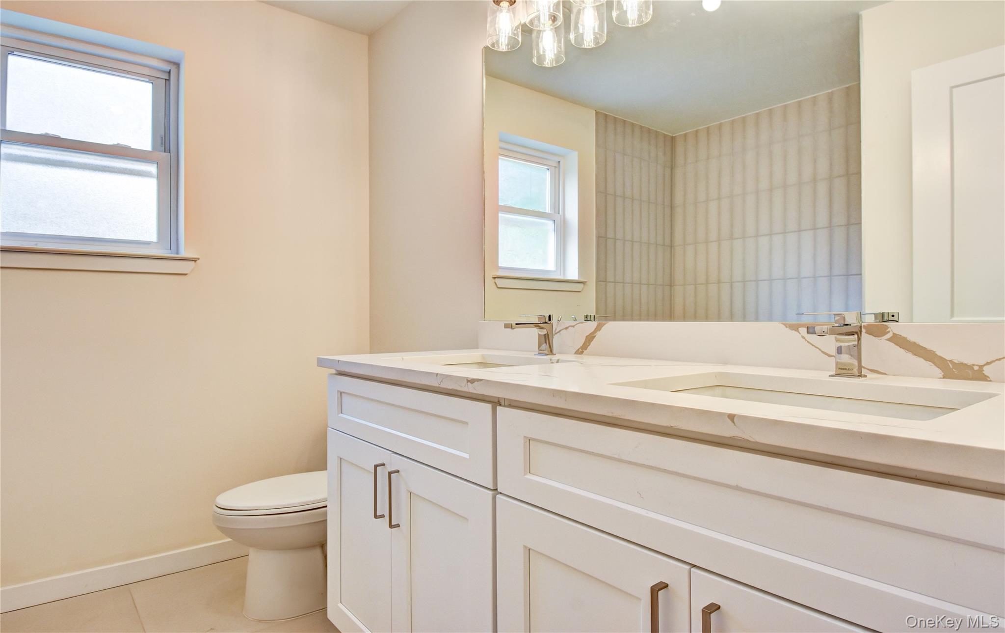 20 Wells Road Newburgh, NY 12550 - Photo 36 of 47 a bathroom with a granite countertop toilet a sink a mirror and a window