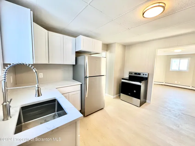 a kitchen with granite countertop a refrigerator and a sink