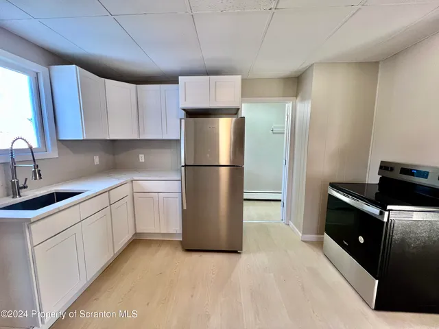 a kitchen with a refrigerator and a sink
