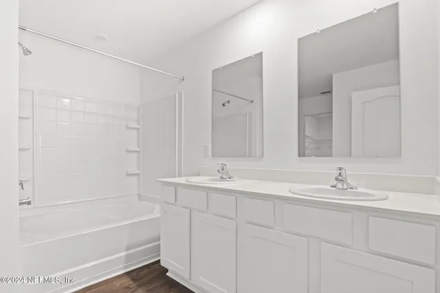 a bathroom with a tub sink and mirror