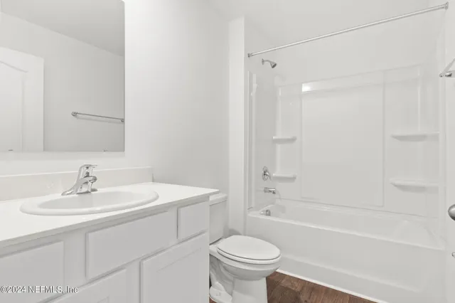 a bathroom with a sink toilet a mirror and shower