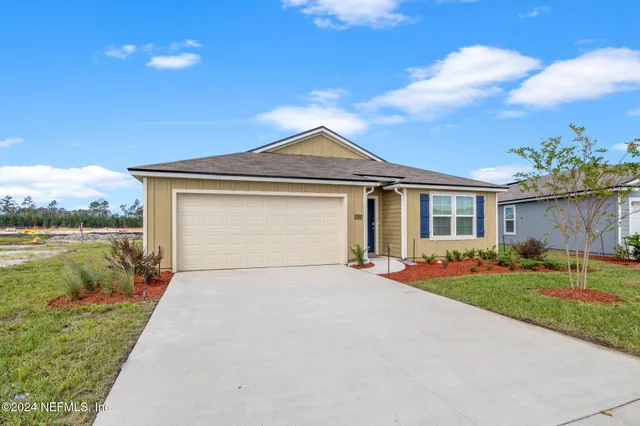 a front view of a house with a garden and yard