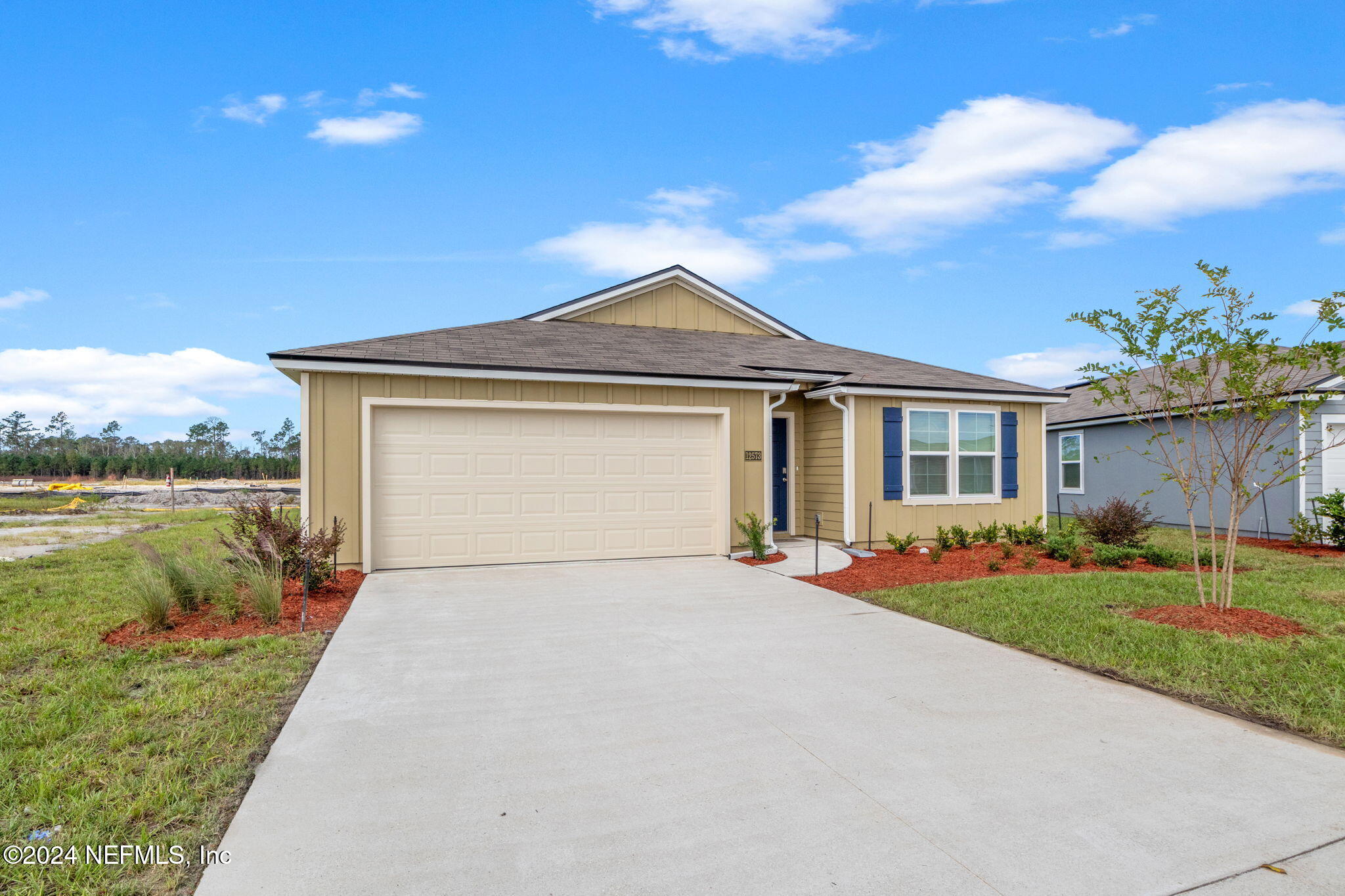 12573 Rubber Fig Terrace Jacksonville, FL 32218 - Photo 2 of 24 a front view of a house with a garden and yard