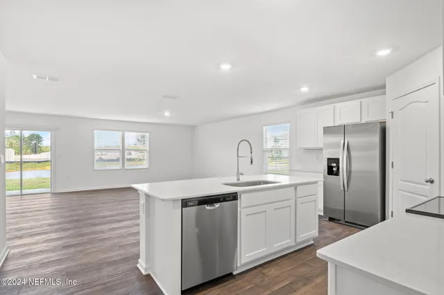 a kitchen with stainless steel appliances a sink a refrigerator and a stove