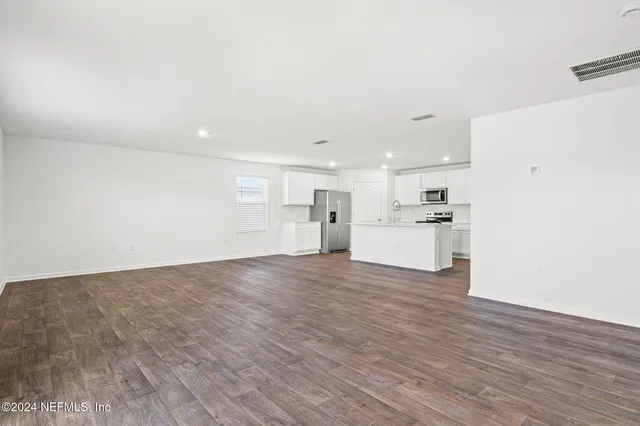 a view of a kitchen with a sink and wooden floor