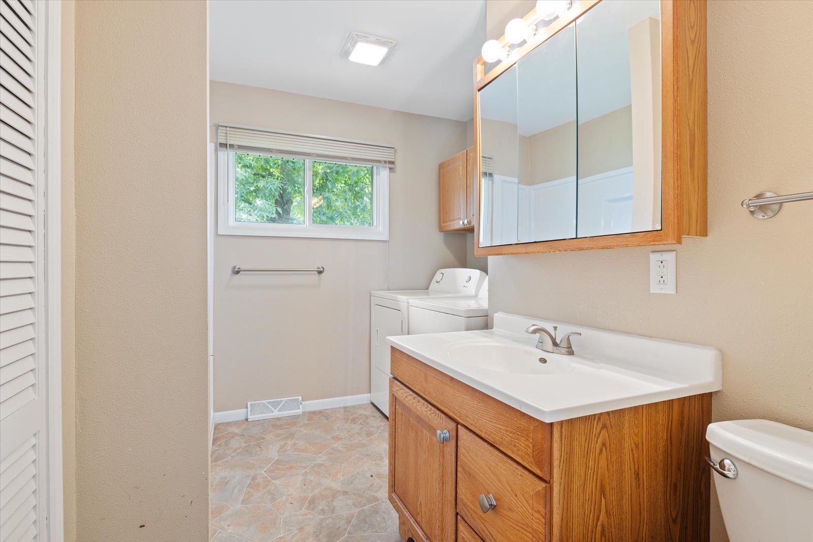 202 Suffolk Drive Hoyt Lakes, MN 55750 - Photo 19 of 33 Full bathroom with a closet, vanity, washer and dryer, and light stone finish flooring