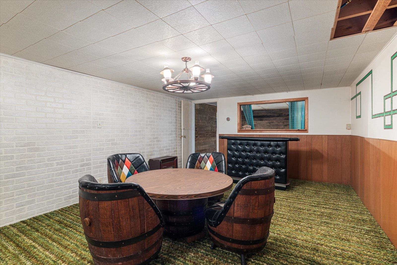 202 Suffolk Drive Hoyt Lakes, MN 55750 - Photo 25 of 33 Carpeted dining space featuring a chandelier, a wainscoted wall, and wood walls
