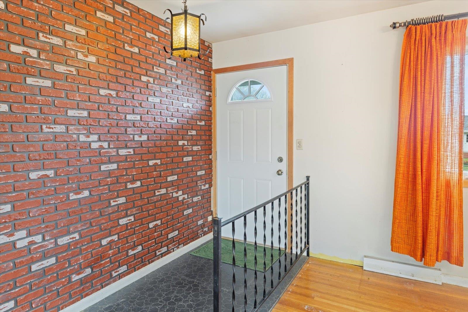 202 Suffolk Drive Hoyt Lakes, MN 55750 - Photo 7 of 33 Foyer with brick wall, wood finished floors, and a baseboard radiator