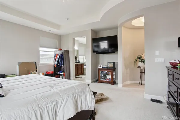 a bed room with a bed a television and a large mirror