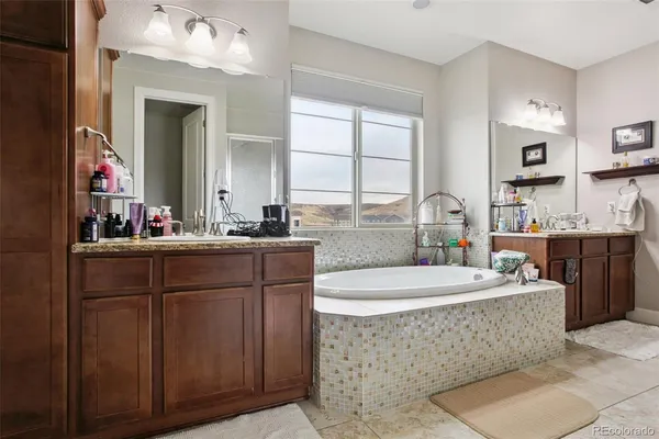 a bathroom with a bathtub a sink a mirror and a window