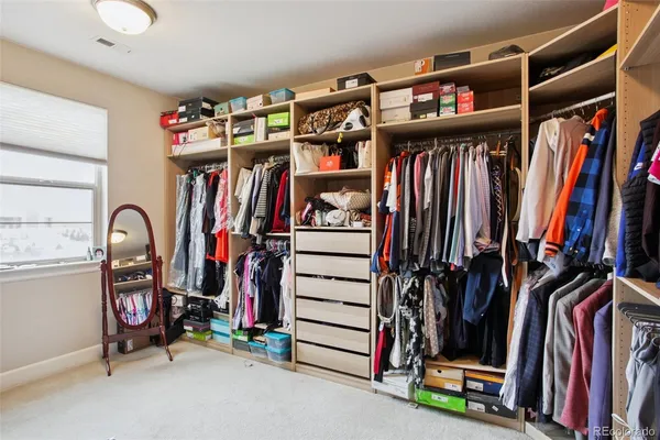 a view of walk in closet with clothes and shoes